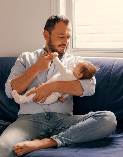Humana Baby hält Papas Finger